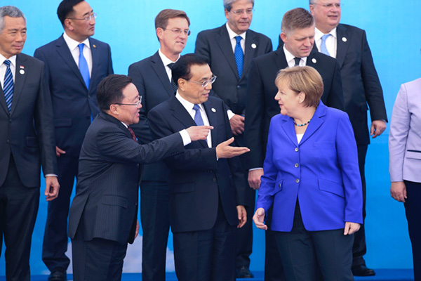 Premier Li Keqiang chats animatedly with Mongolian president Elbegdorj and German Chancellor Merkel before the leaders attending the 11th ASEM summit take group picture on July 15.(Photo/China News Service) Premier Li Keqiang chats animatedly with Mongolian president Elbegdorj and German Chancellor Merkel before the leaders attending the 11th ASEM summit take group picture on July 15.(Photo/China News Service)