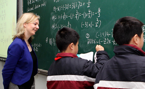 Elizabeth Truss, then British parliamentary undersecretary of state for education and childcare, looks on as two students demonstrate math skills in a primary school in Shanghai during an exchange program in 2014. (Photo/Xinhua)