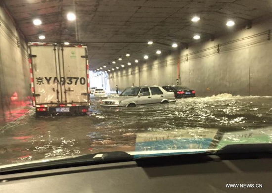 Photo taken by a cellphone shows vehicles stranded in water at a flooded tunnel outside the Beijing West Railway Station in Beijing, capital of China, July 20, 2016. Beijing's meteorological bureau issued an orange alert for rainstorm Wednesday noon. (Xinhua/Liu Guannan) Photo taken by a cellphone shows vehicles stranded in water at a flooded tunnel outside the Beijing West Railway Station in Beijing, capital of China, July 20, 2016. Beijing's meteorological bureau issued an orange alert for rainstorm Wednesday noon. (Xinhua/Liu Guannan)