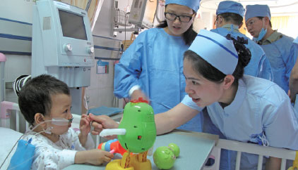 A nurse talks with a child of the Qiong ethnic group, who just had a surgical operation for congenital heart disease, at the Chengdu Military General Hospital. Huang Zhiling / China Daily A nurse talks with a child of the Qiong ethnic group, who just had a surgical operation for congenital heart disease, at the Chengdu Military General Hospital. Huang Zhiling / China Daily