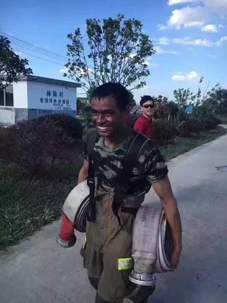 Zhang Xiaofang walks back to the truck carrying two fire hydrants after putting out the sixth fire on Monday. (Photo from Sina Weibo) Zhang Xiaofang walks back to the truck carrying two fire hydrants after putting out the sixth fire on Monday. (Photo from Sina Weibo)