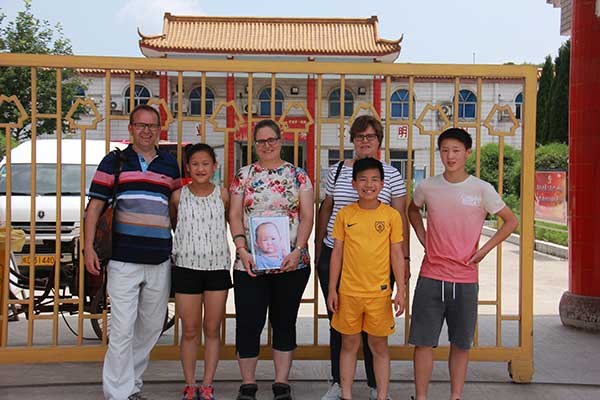 Erika Olzheim (third from left) adopted Callista, a Chinese girl (second from left). Her sister, Andrea De Baar (fourth from left) adopted two boys. They visited the orphanage in Anhui province, where Callista spent her first 18 months.(Zhu Lixin/China Daily) Erika Olzheim (third from left) adopted Callista, a Chinese girl (second from left). Her sister, Andrea De Baar (fourth from left) adopted two boys. They visited the orphanage in Anhui province, where Callista spent her first 18 months.(Zhu Lixin/China Daily)