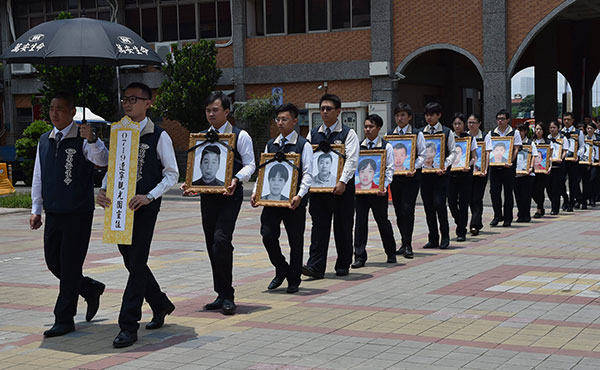 The framed photos of 26 people who died in a tour bus fire in Taiwan on July 19 are escorted to a memorial hall in Taoyuan city on Monday. XU DONGDONG/CHINA NEWS SERVICE The framed photos of 26 people who died in a tour bus fire in Taiwan on July 19 are escorted to a memorial hall in Taoyuan city on Monday. XU DONGDONG/CHINA NEWS SERVICE
