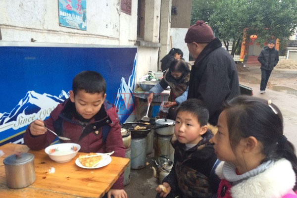 Students of Huangtankou Primary School eat breakfast at Huang Shihua's food stall. (Photo/Zhejiang News) Students of Huangtankou Primary School eat breakfast at Huang Shihua's food stall. (Photo/Zhejiang News)