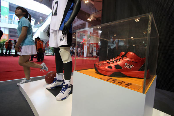 A woman walks past a model in 361 Degrees' stall in a super-market in Jinjiang, Fujian province. 361 Degrees International Limited has become an official supplier of clothing to the Rio 2016 volunteers, technicians and people who participate in the Olympics torch relay. (HE YUAN/CHINA DAIL)