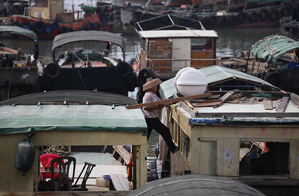 A fisherwoman reinforces her fishing vessel at the Zhapo fishing harbor in Yangjiang, Guangdong province, on Monday as Typhoon Nida headed toward the region. (Photo by ZHANG YOUQIONG/for CHINA DAILY) A fisherwoman reinforces her fishing vessel at the Zhapo fishing harbor in Yangjiang, Guangdong province, on Monday as Typhoon Nida headed toward the region. (Photo by ZHANG YOUQIONG/for CHINA DAILY)