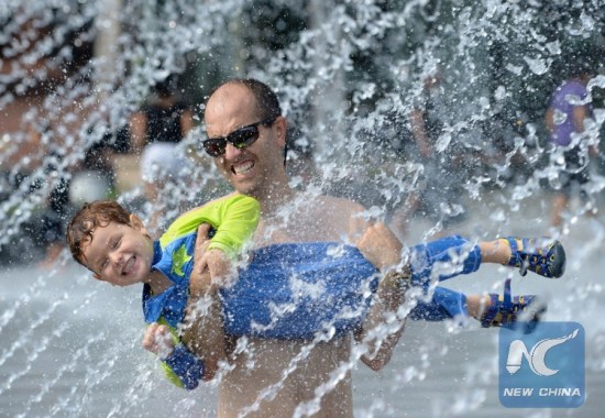 Father and son cooling off in fountain water in Washington D.C., where temperature hits 35 degrees Celsius in June, 2016. (Xinhua Photo) Father and son cooling off in fountain water in Washington D.C., where temperature hits 35 degrees Celsius in June, 2016. (Xinhua Photo)