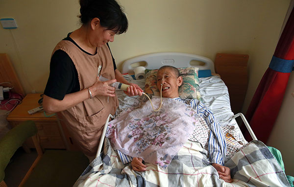 A caregiver helps feed Wang Lingfang, a bedridden 68-year-old patient, via a feeding tube at Puleyuan Nursing Home in Beijing.(Zou Hong/China Daily) A caregiver helps feed Wang Lingfang, a bedridden 68-year-old patient, via a feeding tube at Puleyuan Nursing Home in Beijing.(Zou Hong/China Daily)
