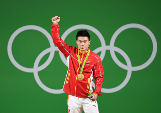 Shi Zhiyong of China celebrates at the awarding ceremony of the men's 69KG weightlifting group A final at the 2016 Rio Olympic Games in Rio de Janeiro, Brazil, on Aug. 9, 2016. Shi Zhiyong won the gold medal with 352KG. (Xinhua/Cheng Min) Shi Zhiyong of China celebrates at the awarding ceremony of the men's 69KG weightlifting group A final at the 2016 Rio Olympic Games in Rio de Janeiro, Brazil, on Aug. 9, 2016. Shi Zhiyong won the gold medal with 352KG. (Xinhua/Cheng Min)