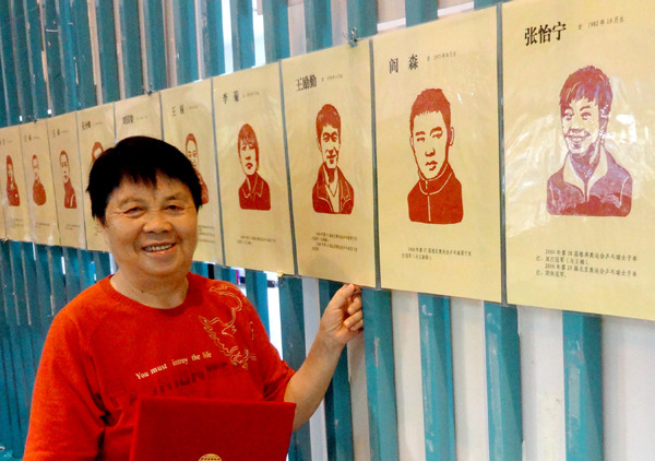 Deng Rongrong with her latest cut-paper album at Xiamen Olympic Museum in Fujian province. (Photo/CHINA DAILY) Deng Rongrong with her latest cut-paper album at Xiamen Olympic Museum in Fujian province. (Photo/CHINA DAILY)