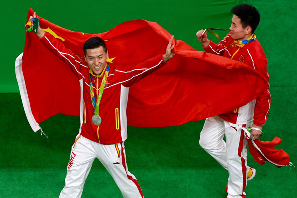 Silver medallist Dong Dong of China (left) and bronze medallist Gao Lei of China pose with their national flags after the men's trampoline final in Rio de Janeiro, Brazil, August 13, 2016. (Photo by Wei Xiaohao/chinadaily.com.cn) Silver medallist Dong Dong of China (left) and bronze medallist Gao Lei of China pose with their national flags after the men's trampoline final in Rio de Janeiro, Brazil, August 13, 2016. (Photo by Wei Xiaohao/chinadaily.com.cn)