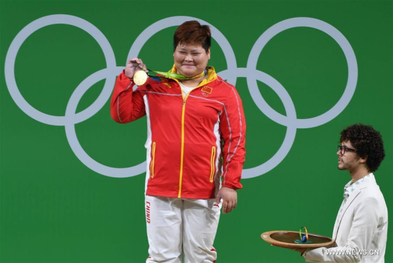 China's Meng Suping shows the gold medal at the awarding ceremony of the women's +75KG weightlifting group A competition at the 2016 Rio Olympic Games in Rio de Janeiro, Brazil, on Aug. 14, 2016. Meng Suping won the gold medal with 307KG. (Photo/Xinhua) China's Meng Suping shows the gold medal at the awarding ceremony of the women's +75KG weightlifting group A competition at the 2016 Rio Olympic Games in Rio de Janeiro, Brazil, on Aug. 14, 2016. Meng Suping won the gold medal with 307KG. (Photo/Xinhua)