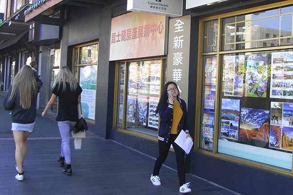 A Chinese student walks past a property trade center in Queensland, Australia. (Photo/China Daily) A Chinese student walks past a property trade center in Queensland, Australia. (Photo/China Daily)