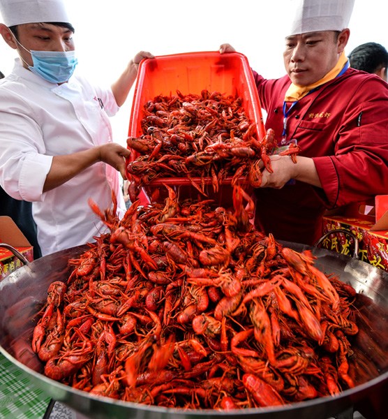 Cooks prepare crayfish for customers. The dish is highly popular in China during Summer time. (Photo/Xinhua) Cooks prepare crayfish for customers. The dish is highly popular in China during Summer time. (Photo/Xinhua)