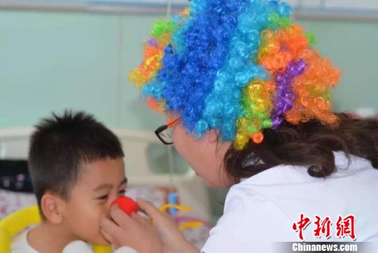 A doctor clown plays with a patient. (Photo/chinanews.com) A doctor clown plays with a patient. (Photo/chinanews.com)