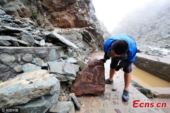 People search for lost cliff paintings as floodwaters recede at the protection zone of the cliff paintings of Helan Mountains in Yinchuan City, Northwest China’s Ningxia Hui Autonomous Region, Aug. 23, 2016. Dating back to prehistoric times, tens of thousands of cliff paintings have been found across 250 kilometers at the Helan Mountains.(Photo/CFP) People search for lost cliff paintings as floodwaters recede at the protection zone of the cliff paintings of Helan Mountains in Yinchuan City, Northwest China’s Ningxia Hui Autonomous Region, Aug. 23, 2016. Dating back to prehistoric times, tens of thousands of cliff paintings have been found across 250 kilometers at the Helan Mountains.(Photo/CFP)