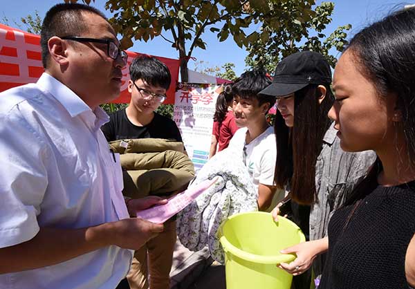 A worker from the Handan Branch of Agricultural Bank of China tells new students how to distinguish telecom fraud at Hebei University of Engineering on their first day at the school.(Hao Qunying/for China Daily) A worker from the Handan Branch of Agricultural Bank of China tells new students how to distinguish telecom fraud at Hebei University of Engineering on their first day at the school.(Hao Qunying/for China Daily)
