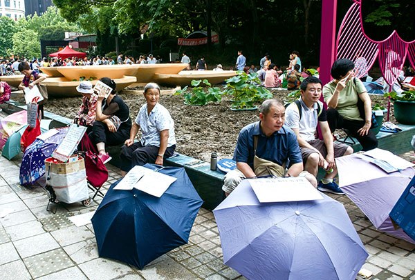 Parents place umbrellas, each carrying sheets of paper containing information about their unmarried children, at the matchmaking market in People's Park in downtown Shanghai last month.(Photo by GAO ERQIANG/CHINA DAILY) Parents place umbrellas, each carrying sheets of paper containing information about their unmarried children, at the matchmaking market in People's Park in downtown Shanghai last month.(Photo by GAO ERQIANG/CHINA DAILY)