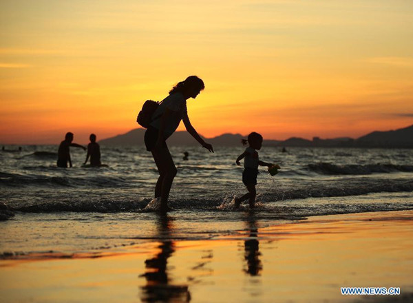 A mother plays with her child at the seashore in sunset in Sanya, south China' Hainan Province, September, 2015. (Photo: Xinhua/Chen Wenwu) A mother plays with her child at the seashore in sunset in Sanya, south China' Hainan Province, September, 2015. (Photo: Xinhua/Chen Wenwu)