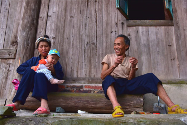 The grandparents take their grandson sitting at the gate of the house. (Photo by Zhang Xingjian/chinadaily.com.cn) The grandparents take their grandson sitting at the gate of the house. (Photo by Zhang Xingjian/chinadaily.com.cn)