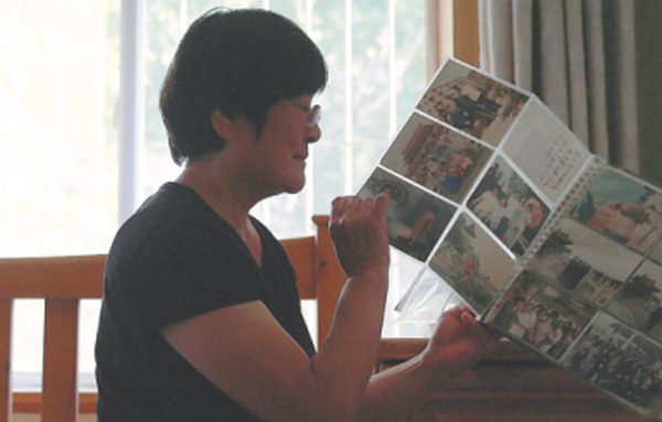 A retiree surnamed Liu, who thought of killing herself after a divorce, looks at her families' photos. (Photo by Zou Hong/China Daily) A retiree surnamed Liu, who thought of killing herself after a divorce, looks at her families' photos. (Photo by Zou Hong/China Daily)