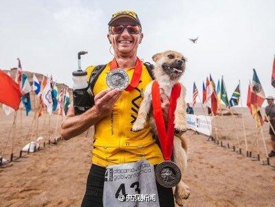 Marathon runner Dion Leonard holds a stray dog that followed him during an extreme marathon in Xinjiang Uygur Autonomous Region. Leonard had raised enough to take the dog named Gobi, which disappeared for days, back to Edinburgh, Scotland. (Photo/Weibo of CCTV) Marathon runner Dion Leonard holds a stray dog that followed him during an extreme marathon in Xinjiang Uygur Autonomous Region. Leonard had raised enough to take the dog named Gobi, which disappeared for days, back to Edinburgh, Scotland. (Photo/Weibo of CCTV)