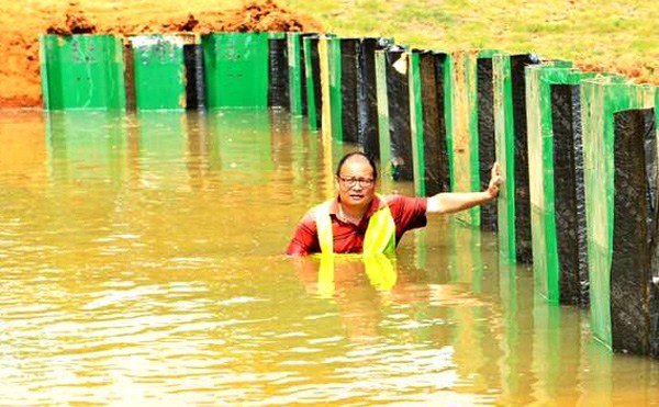 He Lijun stands in water during a test in Wuhan of the flood barrier shield he invented. (Provided To China Daily) He Lijun stands in water during a test in Wuhan of the flood barrier shield he invented. (Provided To China Daily)