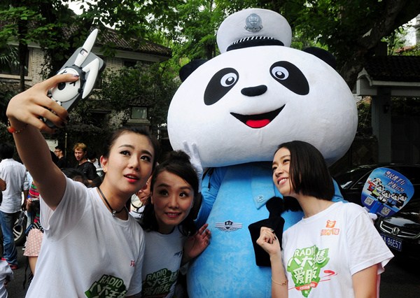 Tourists take a selfie with a Panda Police, around the West Lake area on Sept 8. Lian Guoqing/For China Daily Tourists take a selfie with a Panda Police, around the West Lake area on Sept 8. Lian Guoqing/For China Daily