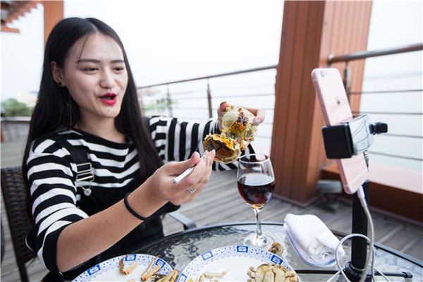 A social media anchorwoman broadcasts live her first taste of the crabs on the side of Yangcheng Lake on Friday. (Photo:China Daily/Xu Kangping) A social media anchorwoman broadcasts live her first taste of the crabs on the side of Yangcheng Lake on Friday. (Photo:China Daily/Xu Kangping)