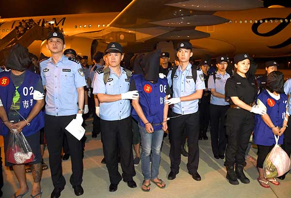 Police officers escort telefraud suspects at Nanjing Lukou International Airport in Jiangsu province last Tuesday. A total of 63 suspects were brought back from Cambodia and accused of defrauding people on the Chinese mainland by posing as law enforcement officials. Han Yuqing / Xinhua Police officers escort telefraud suspects at Nanjing Lukou International Airport in Jiangsu province last Tuesday. A total of 63 suspects were brought back from Cambodia and accused of defrauding people on the Chinese mainland by posing as law enforcement officials. Han Yuqing / Xinhua