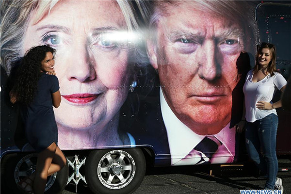 Supporters pose for photos with Hillary Clinton and Donald Trump posters at Hofstra University in New York, the United States on Sept. 26, 2016. The first of three presidential debates between the Democratic and Republican nominees, Hillary Clinton and Donald Trump, will be held Monday at Hofstra University in New York. (Xinhua/Qin Lang) Supporters pose for photos with Hillary Clinton and Donald Trump posters at Hofstra University in New York, the United States on Sept. 26, 2016. The first of three presidential debates between the Democratic and Republican nominees, Hillary Clinton and Donald Trump, will be held Monday at Hofstra University in New York. (Xinhua/Qin Lang)