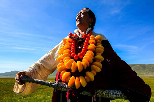 Kangba men's costume is more simple and loose, compared with the women's, and show off their masculinity and strength. Men's accessories made of amber and corallites are larger and also heavier. (Photo by Han Jiajun/chinadaily.com.cn) Kangba men's costume is more simple and loose, compared with the women's, and show off their masculinity and strength. Men's accessories made of amber and corallites are larger and also heavier. (Photo by Han Jiajun/chinadaily.com.cn)