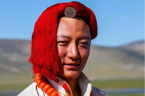 The red decorations - twisted red wires - on men's heads are part of the traditional dress. (Photo by Han Jiajun/chinadaily.com.cn) The red decorations - twisted red wires - on men's heads are part of the traditional dress. (Photo by Han Jiajun/chinadaily.com.cn)