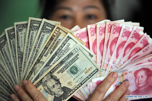 A resident shows China's yuan and US dollar banknotes in Qionghai, South China's Hainan province, January 7, 2016. (Photo/Xinhua) A resident shows China's yuan and US dollar banknotes in Qionghai, South China's Hainan province, January 7, 2016. (Photo/Xinhua)