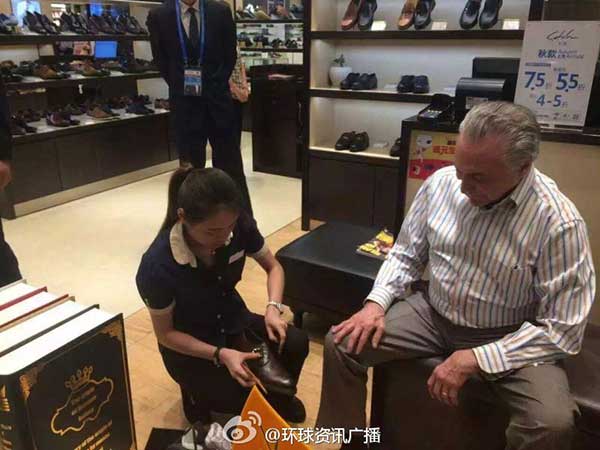 A shop assistant helps Temer try on a pair of shoes. (Photo/Sina Weibo) A shop assistant helps Temer try on a pair of shoes. (Photo/Sina Weibo)