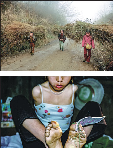 Top: Xiang Liping (right) and her two younger brothers carry bundles of straw home in November, 2002. Above: Without arms,Xiang uses her feet to do needlework. Top: Xiang Liping (right) and her two younger brothers carry bundles of straw home in November, 2002. Above: Without arms,Xiang uses her feet to do needlework.