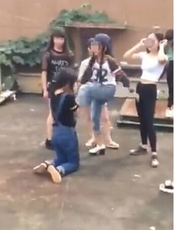 A number of girls beat and kick a fellow female student who kneels down on the ground in Yongxin county, Jiangxi province. (Photo/ Weibo) A number of girls beat and kick a fellow female student who kneels down on the ground in Yongxin county, Jiangxi province. (Photo/ Weibo)