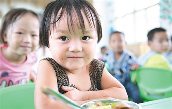 Shi Jiahui, 3, eats lunch at the Houzhai Village Kindergarten in Tongren, Guizhou province. (Photos By Hou Liqiang / China Daily) Shi Jiahui, 3, eats lunch at the Houzhai Village Kindergarten in Tongren, Guizhou province. (Photos By Hou Liqiang / China Daily)