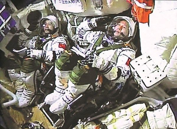 Astronauts Jing Haipeng (right) and Chen Dong salute inside the spacecraft at the moment of launching on Monday. (Photo/Xinhua) Astronauts Jing Haipeng (right) and Chen Dong salute inside the spacecraft at the moment of launching on Monday. (Photo/Xinhua)