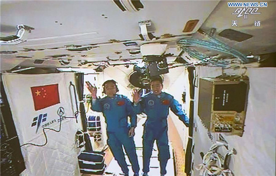 Photo taken on Oct. 19, 2016 shows the screen at the Beijing Aerospace Control Center showing the two Chinese astronauts Jing Haipeng (L) and Chen Dong waving hands in the space lab Tiangong-2. The two astronauts onboard the Shenzhou-11 spacecraft entered the space lab Tiangong-2 Wednesday morning. (Xinhua/Ju Zhenhua) Photo taken on Oct. 19, 2016 shows the screen at the Beijing Aerospace Control Center showing the two Chinese astronauts Jing Haipeng (L) and Chen Dong waving hands in the space lab Tiangong-2. The two astronauts onboard the Shenzhou-11 spacecraft entered the space lab Tiangong-2 Wednesday morning. (Xinhua/Ju Zhenhua)