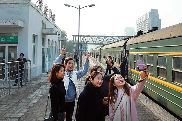Students from Macao, who are studying in Beijing, take photos at Qinghuayuan Railway Station as their train makes a stop at the station on Tuesday.Zou Hong / China Daily Students from Macao, who are studying in Beijing, take photos at Qinghuayuan Railway Station as their train makes a stop at the station on Tuesday.Zou Hong / China Daily