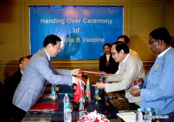 Chinese Ambassador to Myanmar Hong Liang (1st L) changes documents with Myanmar's Minister for Health and Sport Dr. Myint Htwe (2nd R) during a handover ceremony of Hepatitis B Vaccine in Yangon, Myanmar, Oct. 31, 2016. (Photo:Xinhua/U Aung)