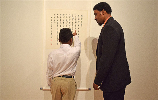 Menelik Gurnell, a student from Global Learning Village, reads a poem aloud to his father. (TIFFANY WANG / FOR CHINA DAILY) Menelik Gurnell, a student from Global Learning Village, reads a poem aloud to his father. (TIFFANY WANG / FOR CHINA DAILY)