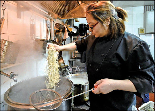Zhang Ziyu prepares food for customers at the noodle restaurant she owns in Beijing. Even though she does not hold Beijing hukou, the Chongqing native has been pursuing her dreams in the capital city for four years.Photos By Cao Yang / For China Daily Zhang Ziyu prepares food for customers at the noodle restaurant she owns in Beijing. Even though she does not hold Beijing hukou, the Chongqing native has been pursuing her dreams in the capital city for four years.Photos By Cao Yang / For China Daily