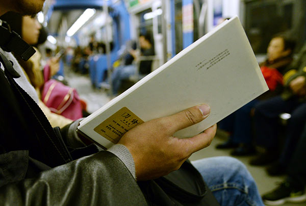 A passenger reads one of 40 books placed inside the light-rail system in Chongqing by author and bookstore owner Jiang Lin. (Photo provided to China Daily) A passenger reads one of 40 books placed inside the light-rail system in Chongqing by author and bookstore owner Jiang Lin. (Photo provided to China Daily)