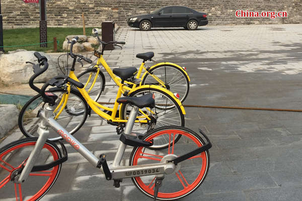 A Mobike is parked next to two Ofo bikes. (Photo/ China.org.cn) A Mobike is parked next to two Ofo bikes. (Photo/ China.org.cn)