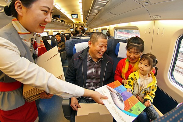 An attendant hands a commemorative envelope to passengers on the maiden trip of the Qingdao-Rongcheng high-speed rail in Shandong province on Wednesday. TANG KE/CHINA DAILY An attendant hands a commemorative envelope to passengers on the maiden trip of the Qingdao-Rongcheng high-speed rail in Shandong province on Wednesday. TANG KE/CHINA DAILY