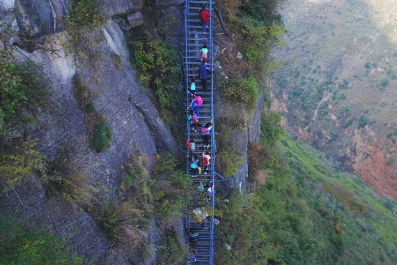 Children climb a steel ladder leading to the cliff village in Sichuan province on Saturday, November 19, 2016. (Photo/Beijing News) Children climb a steel ladder leading to the cliff village in Sichuan province on Saturday, November 19, 2016. (Photo/Beijing News)