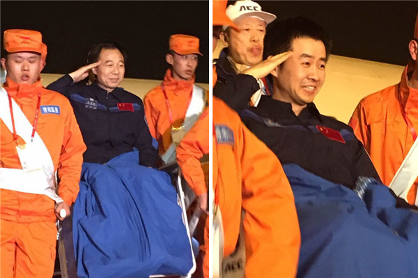 Chinese astronauts Jing Haipeng (L) and Chen Dong salute as they are carried off the plane that brought them to Beijing on Friday evening. The two had returned to Earth earlier the same day after a monthlong space mission.(Photo: Xinhua/Yang Xin) Chinese astronauts Jing Haipeng (L) and Chen Dong salute as they are carried off the plane that brought them to Beijing on Friday evening. The two had returned to Earth earlier the same day after a monthlong space mission.(Photo: Xinhua/Yang Xin)