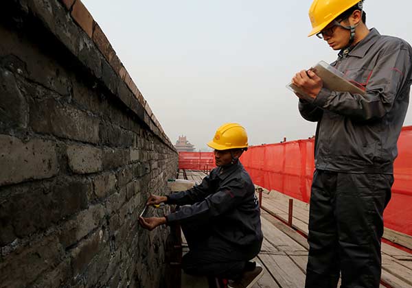 Workers take measurements on Saturday as they prepare for restoration of the walls of the Palace Museum in Beijing. JIANG DONG/CHINA DAILY Workers take measurements on Saturday as they prepare for restoration of the walls of the Palace Museum in Beijing. JIANG DONG/CHINA DAILY